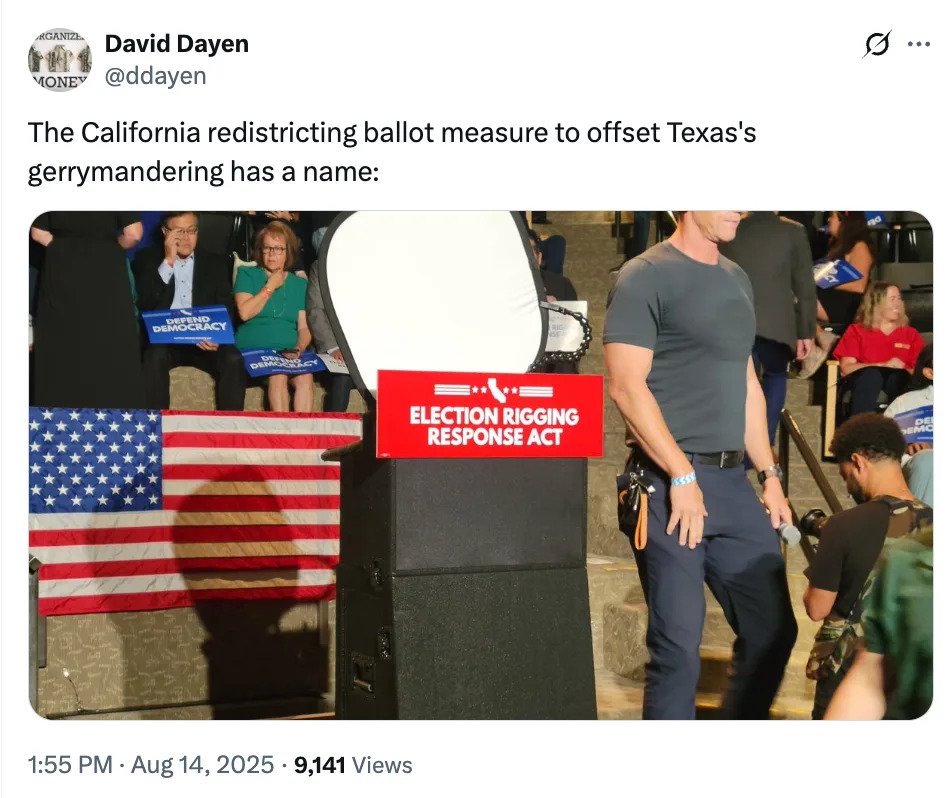A man walks past a podium with a sign reading "Election Rigging Response Act"; people in the background hold signs about California and Texas politics