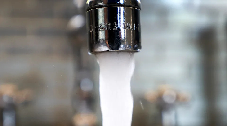 Water runs from a kitchen faucet.