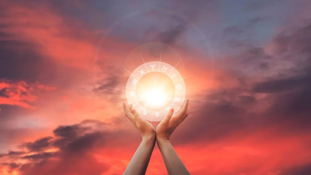 zodiac signs inside of horoscope circle in woman hand at sunset. astrology and horoscopes.