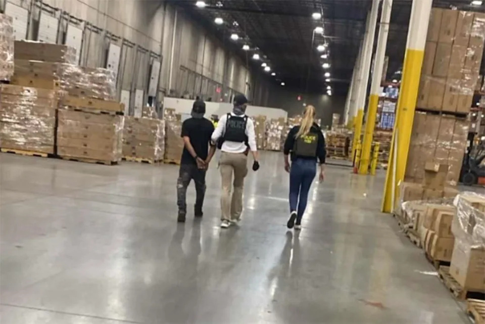 Officers arresting people inside a warehouse. (Cosecha New Jersey)