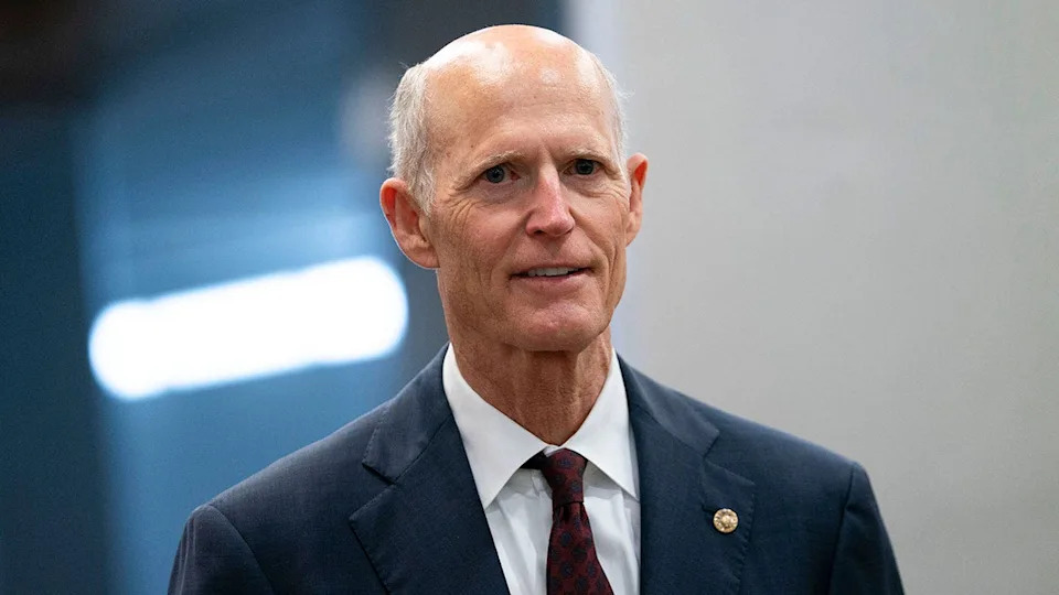 Senator Rick Scott smiling in dark suit