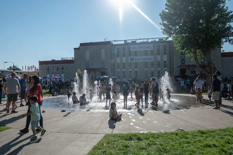 A group of youngsters cools off in the fountain outside the Palace of Agriculture during the 2024 Colorado State Fair in Pueblo.