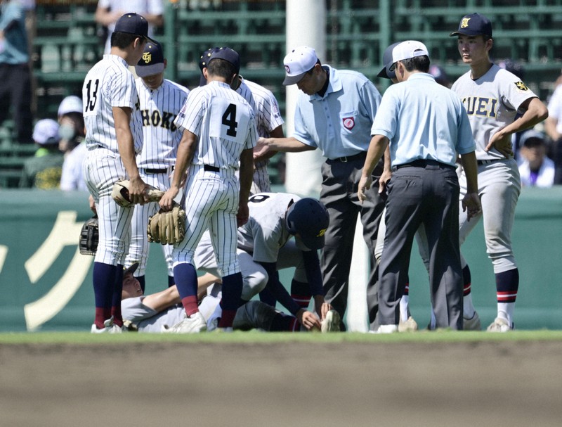 【仙台育英－鳥取城北】八回裏終了後、外野グラウンドで動けなくなる仙台育英の田山＝阪神甲子園球場で2025年8月6日、藤井達也撮影