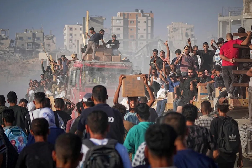 Palestinians on a food truck in Gaza (AP)