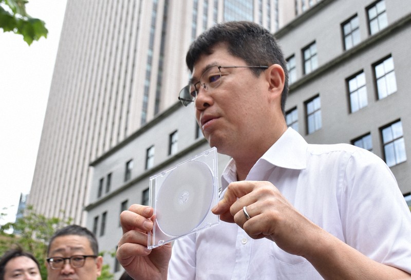 財務省から開示された資料が入ったDVDを手にする生越照幸弁護士＝東京都千代田区で2025年8月13日午後0時50分、高田奈実撮影
