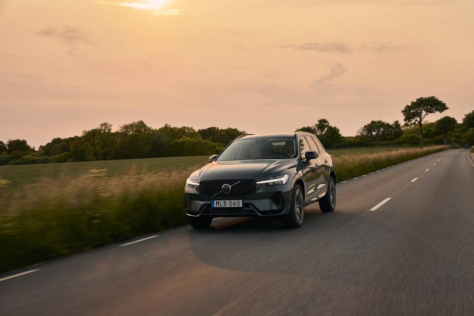 volvo suv driving on a rural road during sunset