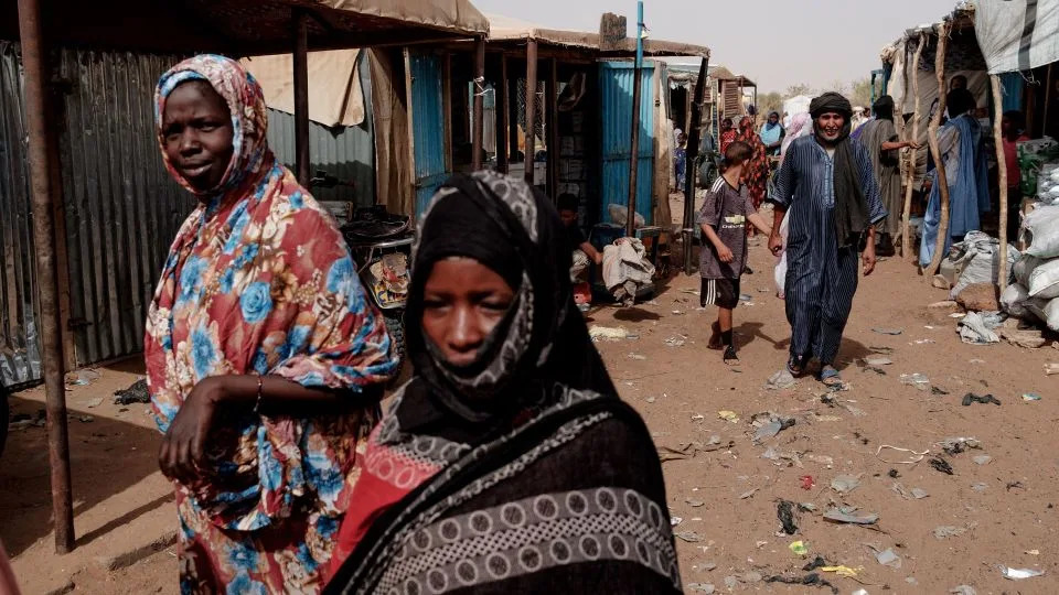 People walk through the weekly market in M'Berra camp in Bassikounou on June 7, 2022. The camp, in Mauritania, is one of the largest in West Africa, hosting refugees fleeing violence in Mali. - Guy Peterson/AFP/Getty Images