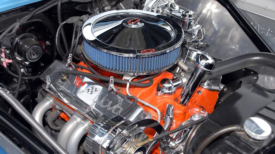 A chromed and customized 1967 Chevrolet Nova small block V8 engine on display at a car show