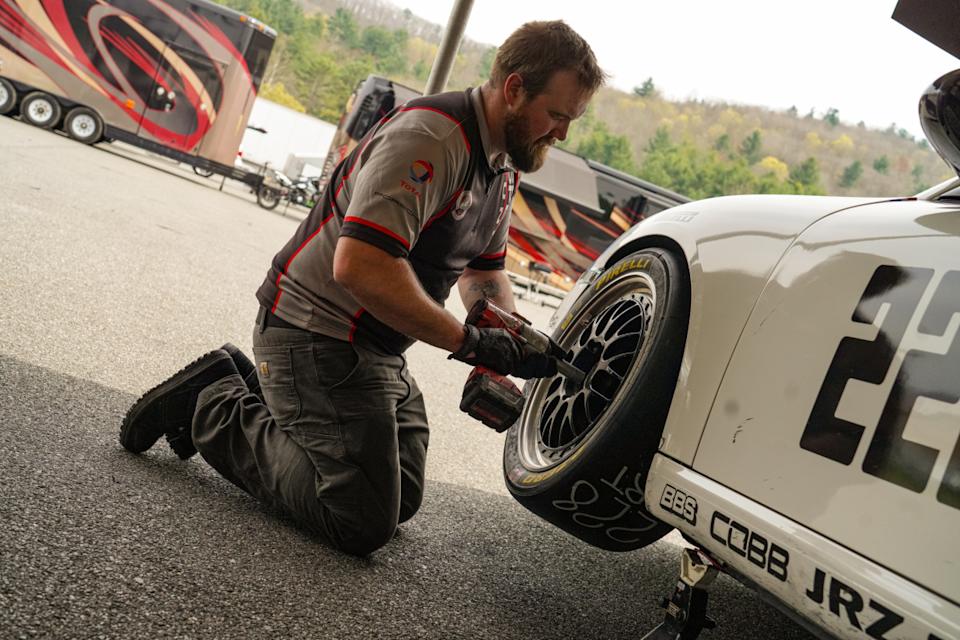 An SST employee works on a wheel while supporting a customer's racing pursuit.