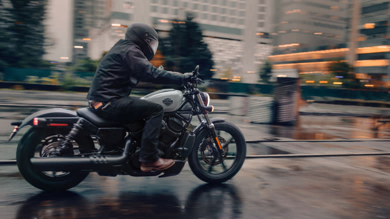 A Harley-Davidson Nightster being ridden on a wet street