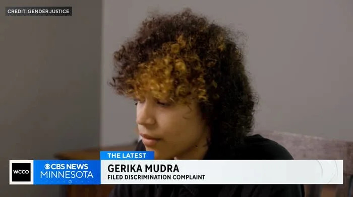Person with curly hair looking down; CBS News Minnesota reports on Gerika Mudra filing a discrimination complaint