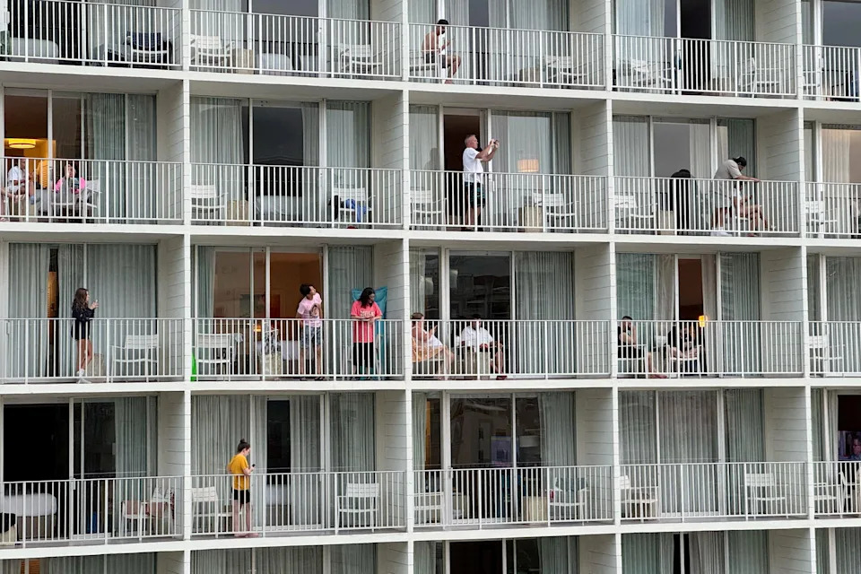 Guests stand on balconies at 'Alohilani Resort Waikiki Beach in Honolulu amid warnings of potential tsunami waves on July 29.
