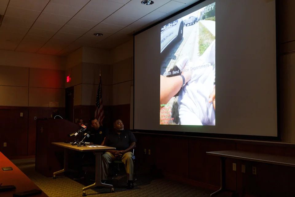 South Bend Chief of Police Scott Ruszkowski, center, and police Capt. David Herron, right, watch body camera footage from an incident that took place on Aug. 15 being played for members of the media at the department's headquarters on Wednesday, Aug. 20, 2025, in South Bend.