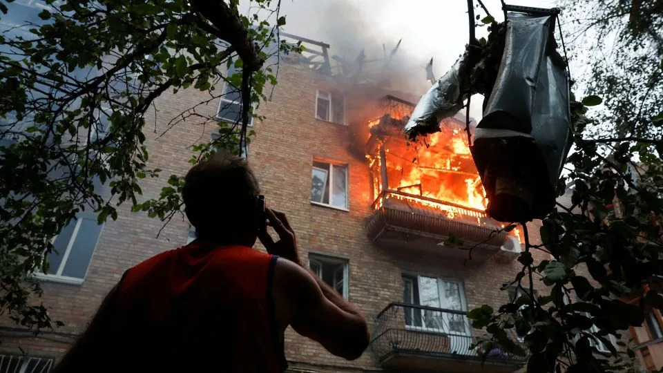 A resident looks on at the site of an apartment building hit during Russian missile and drone strikes in Kyiv, Ukraine, on July 3. - Thomas Peter/Reuters