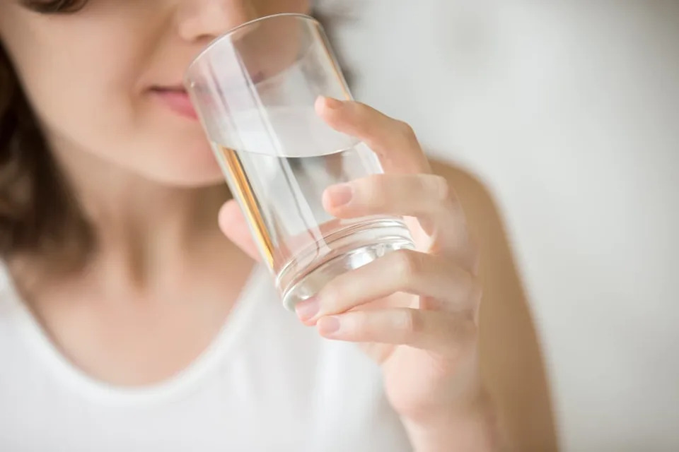 Woman drinking water from a glass.