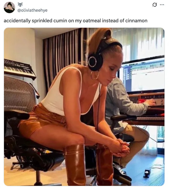 Person sitting in a studio wearing headphones, white top, tan leather shorts, and boots. Caption jokes about using cumin on oatmeal instead of cinnamon