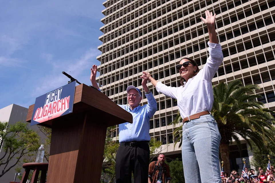 Sanders and AOC waving to the crowd