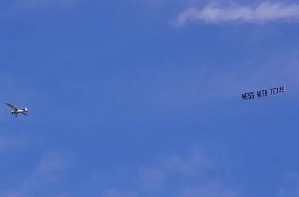  A plane flies over the State House Monday trailing a “MESS WITH TEXAS” banner. (Photo by Danielle J. Brown/Maryland Matters).