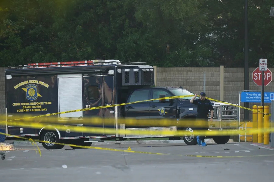 Law enforcement officers are seen stationed outside a Walmart where several people were stabbed in a violent attack Saturday, July 26, 2025, in Traverse City, Mich. (AP Photo/Ryan Sun)