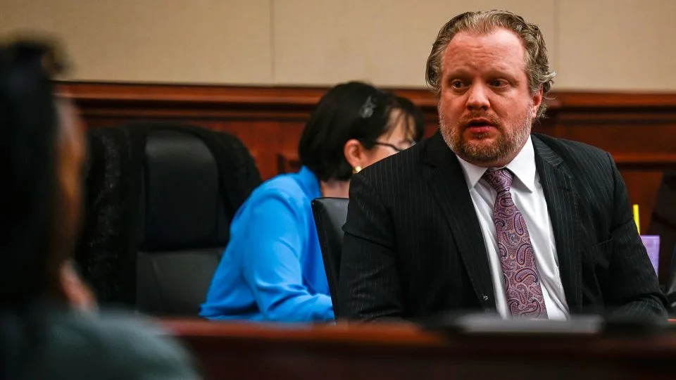 James Craig talks with his family from his seat before opening arguments in his murder trial at the Arapahoe District Court on July 15 in Centennial, Colorado. - Stephen Swofford/Pool/Denver Gazette/AP