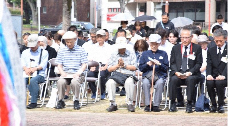 千羽鶴の飾られた慰霊塔に向かって黙とうする参列者＝北九州市八幡東区で2025年8月8日午前9時18分、宮本勝行撮影