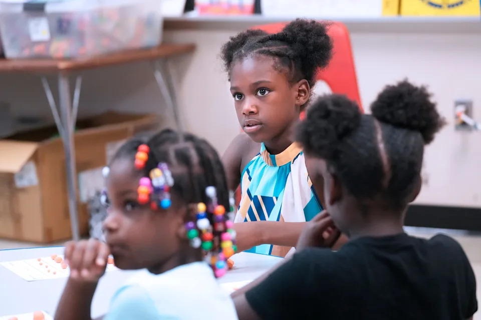 Former first-graders from left, Jaryia, Brielle and Kinzley listen during summer school at Elm Creative Arts in Milwaukee.