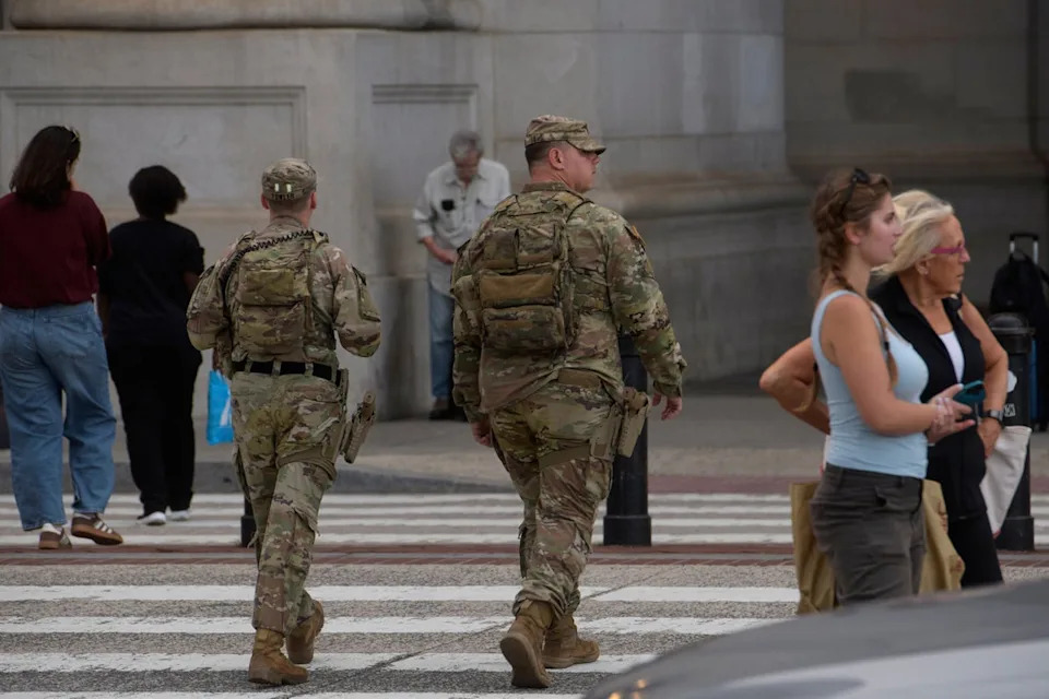Advocacy groups warn that arming troops is a ‘dangerous escalation’ as the president brags about a drop in murders in the nation’s capital (AP)