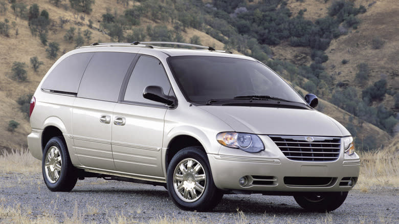Chrysler minivan from 2005 parked in a field with hills in the background