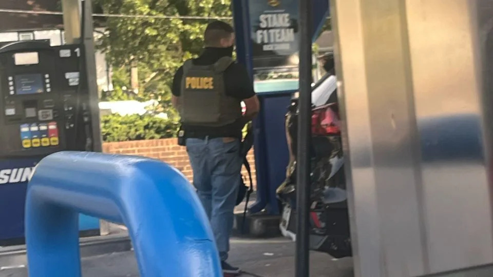 A masked ICE agent stands at a gas station in Takoma Park, Maryland. - Chelsea Bailey/CNN