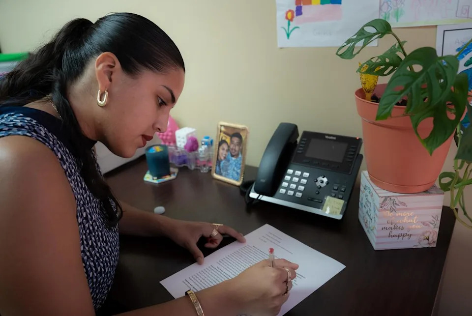 Katerin M.S., 24, a graduate student in social work at the University of Houston, works full time as a case worker while managing her schoolwork in her office. She edits a copy of her homework for a class on Critical Practice with Latinx Communities on her desk on Sunday, Aug. 17, 2025, in Houston.