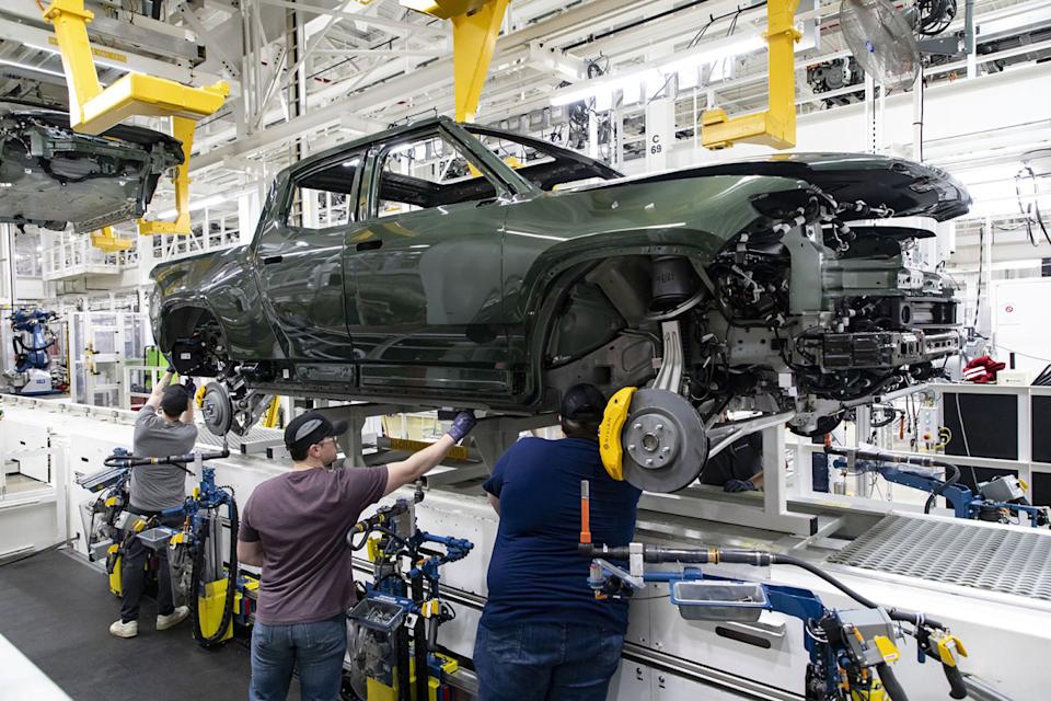 Workers lower an R1T truck body onto a chassis in the assembly line at the Rivian electric vehicle plant.Chicago Tribune/Getty Images