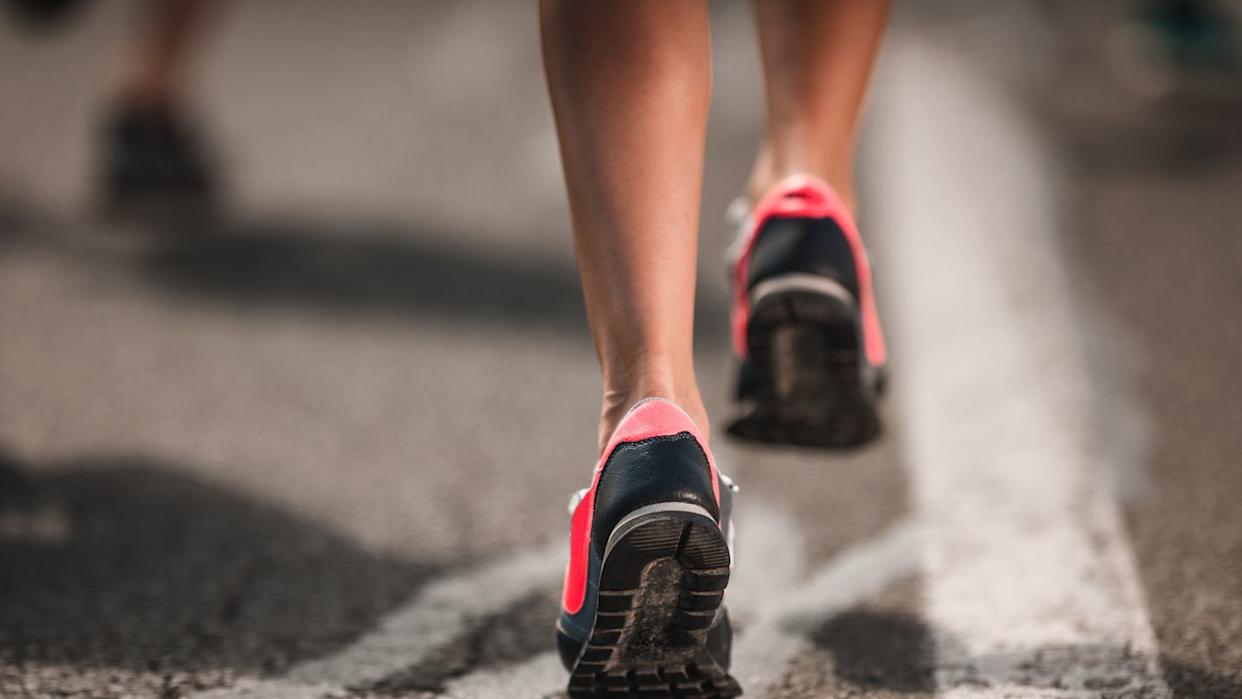 close up of unrecognizable marathon runner in motion on the road.