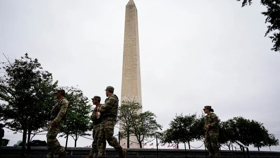 Members of the National Guard walk near the Washington Monument on August 21, 2025. - Al Drago/Reuters