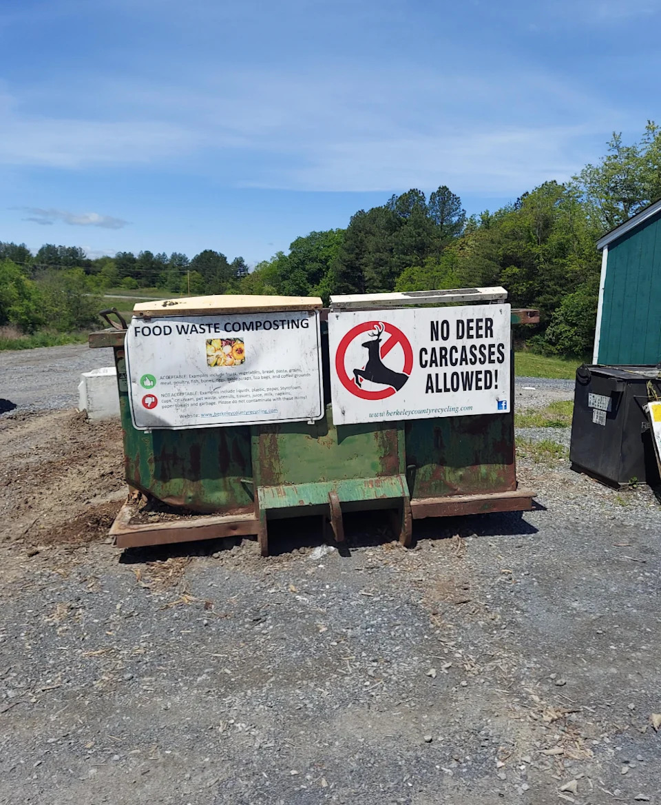 Composting bin with signs: "Food Waste Composting" and "No Deer Carcasses Allowed!" in rural area