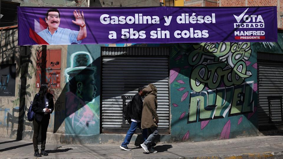 La gente pasa junto a una pancarta del candidato presidencial boliviano Manfred Reyes Villa, del partido "Súmate", en La Paz.