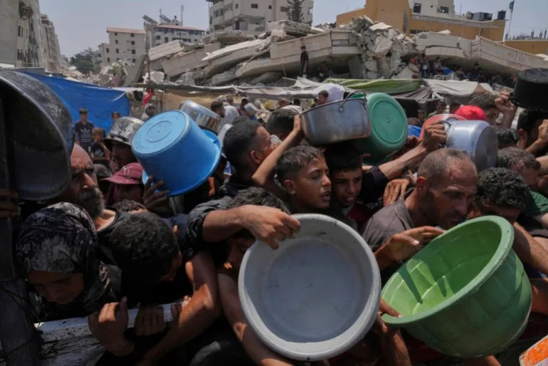 Palestinians struggle to get donated food at a community kitchen, in Gaza City, northern Gaza Strip, Saturday, July 26, 2025 [Abdel Kareem Hana/AP Photo]