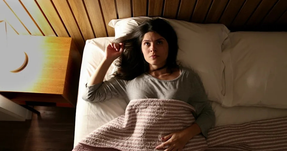 Worried woman unable to fall asleep.