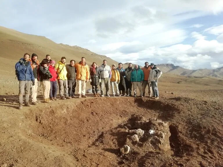 El equipo de científicos argentinos y japoneses junto al hallazago en el sitio de Estancia Anita.