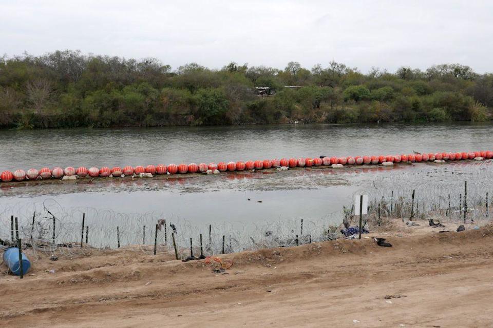 Cadena de boyas naranjas con púas sobre el Río Bravo