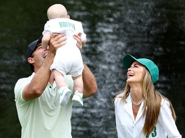 Warren Little/Getty Brooks Koepka holds his son, Crew, with Jena Sims