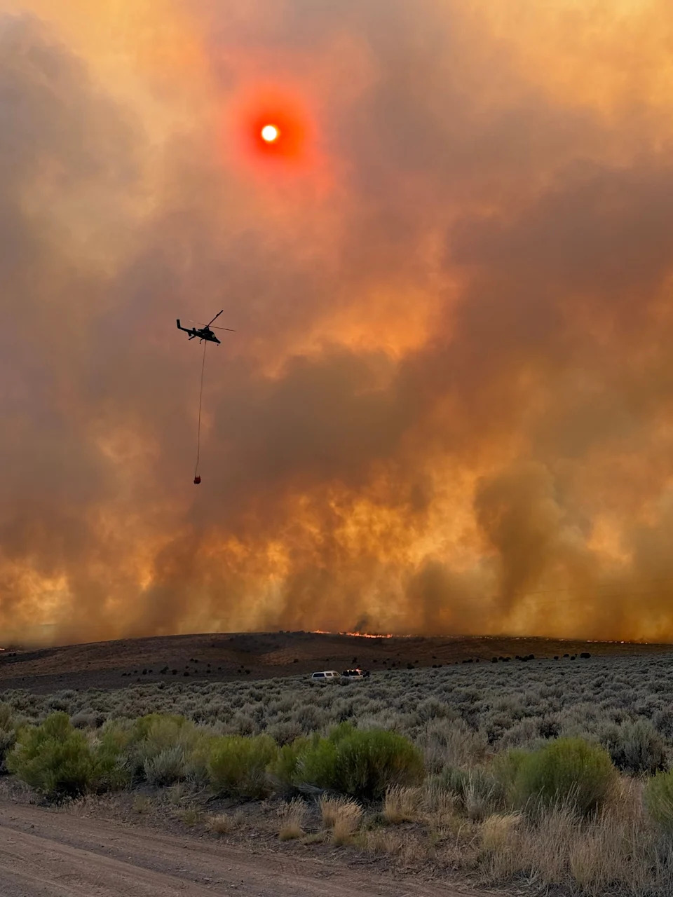 A helicopter brings water to drop on the Monroe Canyon fire.