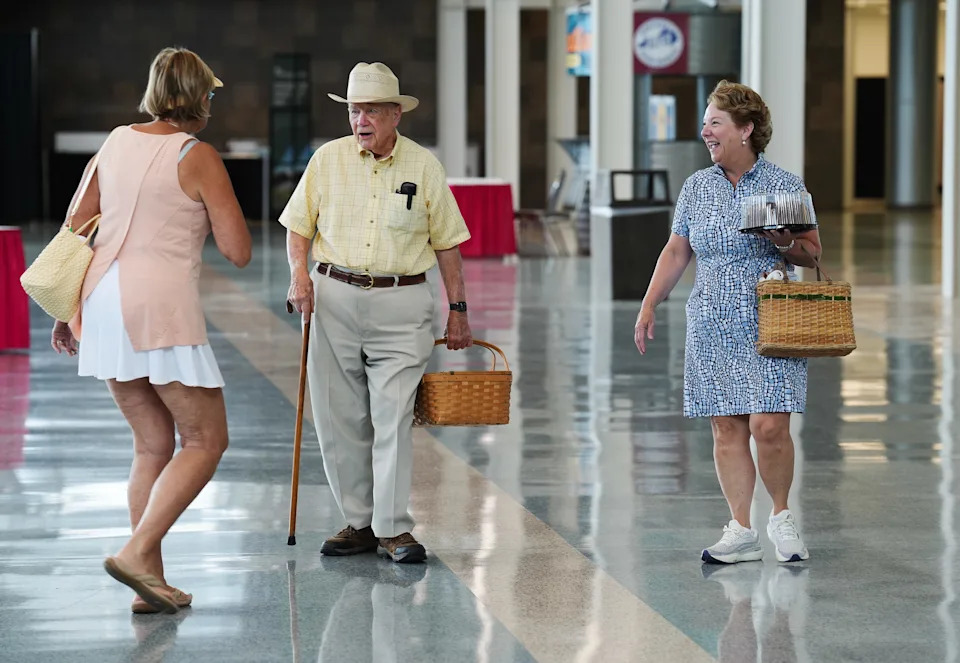 Bob Hall, 95, center, and his daughter Julia Hall chatted with another contestant and wished each other good luck as they dropped off his entries of an apple pie and a pound cake to enter into the culinary contest at the Kentucky State Fairgrounds in Louisville, Ky. on Aug. 11, 2025.