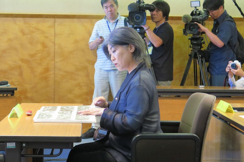 委員から提示された東洋大の卒業アルバムを確認する田久保真紀市長＝静岡県伊東市の市議会で2025年8月13日、若井耕司撮影