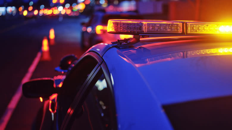 A police car's flashing lights at nighttime against a city background that's out of focus