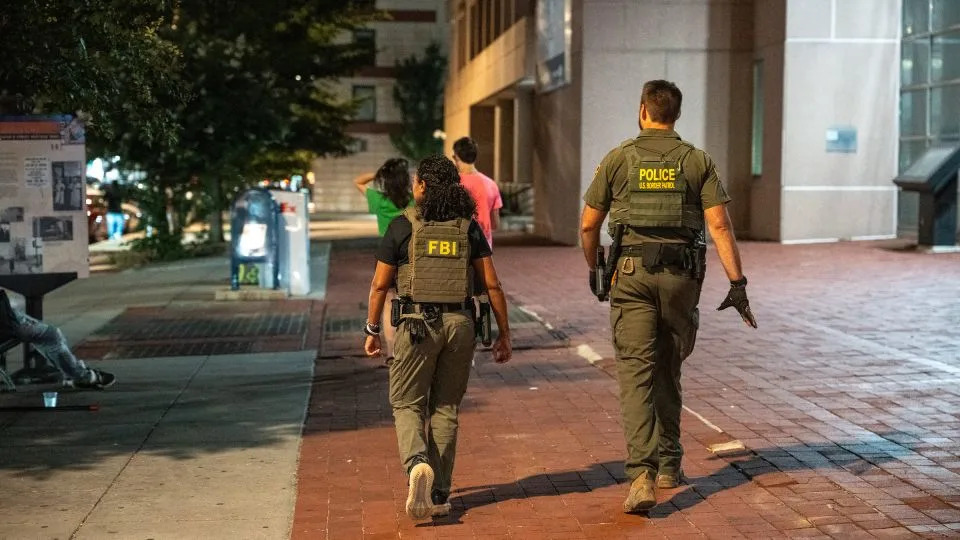 FBI and Border Patrol officers walk along the U Street corridor as part of a federal law enforcement deployment to the nation's capital on August 10 in Washington, DC. - Andrew Leyden/Getty Images