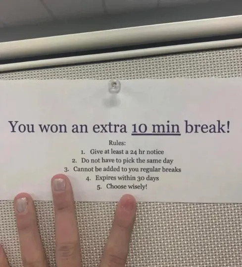Sign announcing a 10-min break reward with rules; person's hand with victory sign