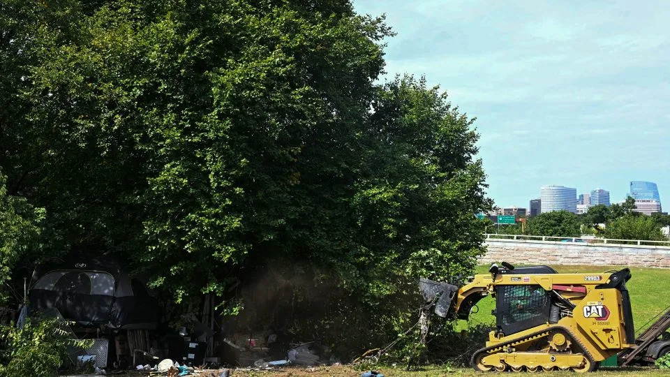 DC city workers dismantle tents and remove personal belongings during a sweep of a homeless encampment in the Foggy Bottom neighborhood of Washington, DC, on Thursday. - Jim Watson/AFP/Getty Images