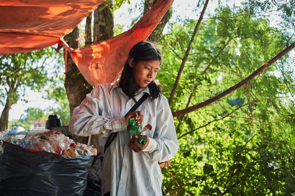 Isela Santiago Morales, que trabaja con su familia recogiendo botellas PET, clasifica residuos reciclables en el vertedero municipal en Axtla de Terrazas, México, el miércoles 20 de agosto de 2025. (AP Foto/Mauricio Palos)