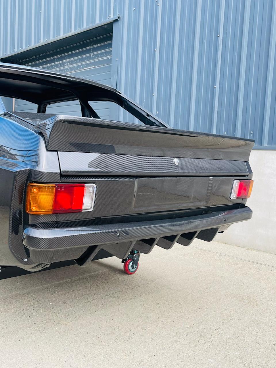 rear view of a car showcasing a carbon fiber spoiler and diffuser