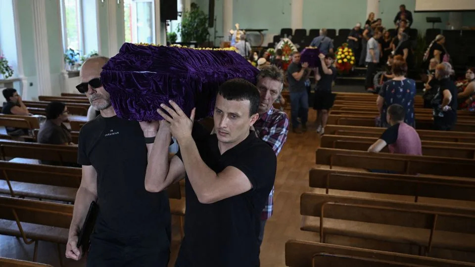 Pallbearers carry coffins following a funeral ceremony for a couple and their son, in a church in Sloviansk, Ukraine, on August 5. - Genya Savilov/AFP/Getty Images